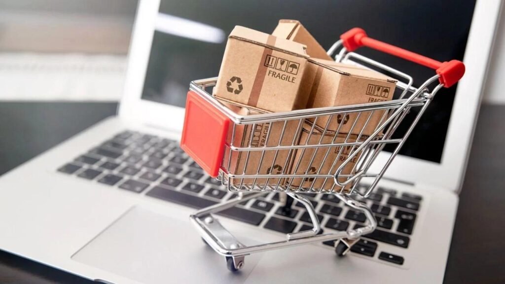 Image showing a shopping cart filled with product boxes on a laptop, illustrating ecommerce branding and product graphic design for online stores, featured in the article “Product graphic design for ecommerce brands.”